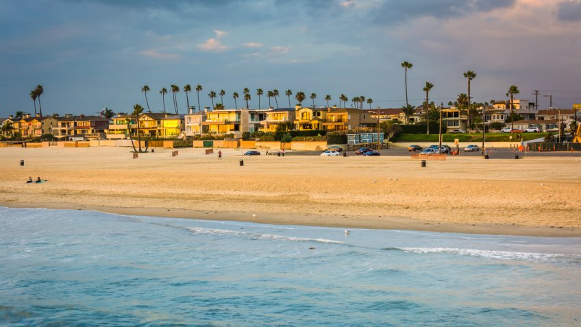 Waves in the Pacific Ocean and view of the beach at sunset in Seal Beach, California.