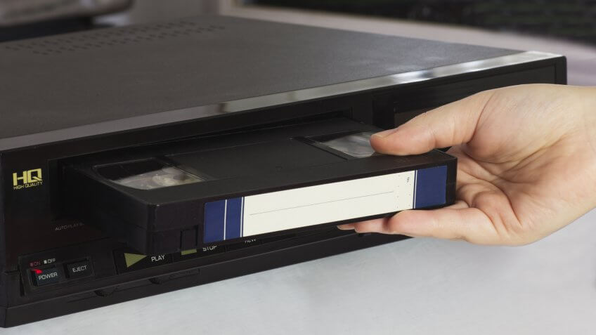 Female Hand Puts Old Video Tape into the Old Video Player.