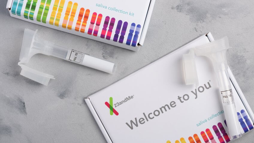 Kiev, Ukraine - 17 October 2018: 23andMe personal genetic test saliva collection kit, with tube and box on table overhead view.