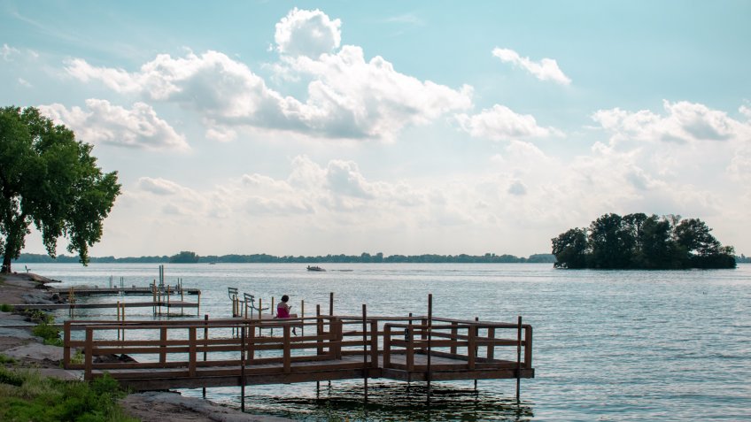 A woman sitting at the end of the pier at waterworks park in beaver dam Wisconsin - Image.