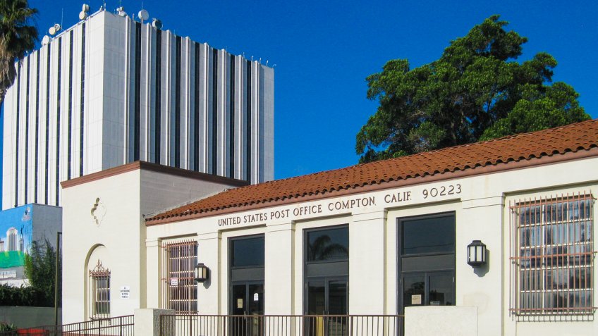 Compton, California USA - June 9, 2017: historic 1935 WPA United States Post Office exterior, 101 S Willowbrook Ave, Spanish Revival, near Civic Plaza, Los Angeles Superior Courthouse in background.