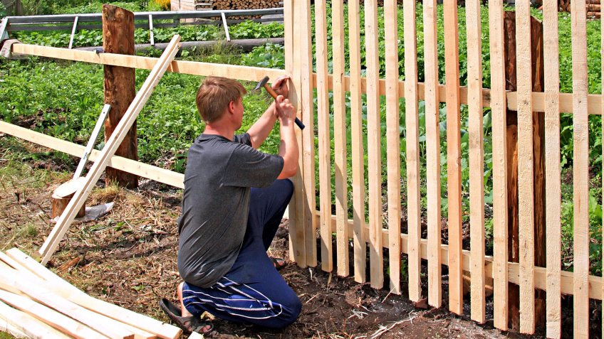man builds fence - Image.