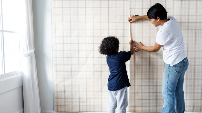 Kid helping mom install wallpaper - Image.