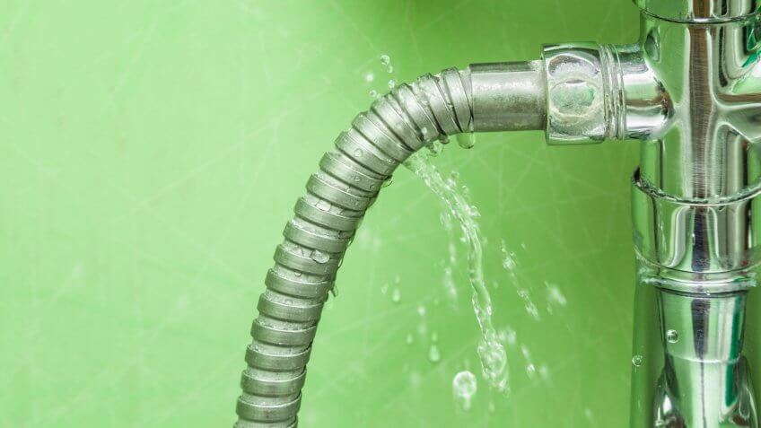 Damaged leaking water tap hose in the bathroom of house, flat or other place.
