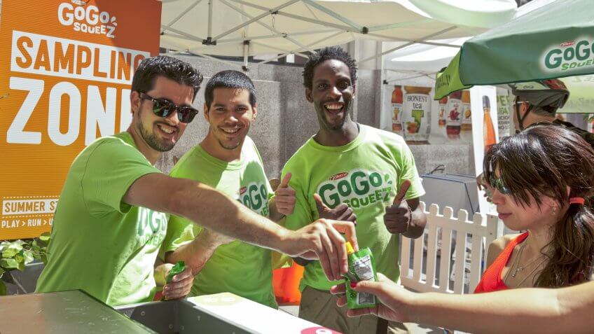 NEW YORK - AUGUST 04: Sales representatives of GoGo Squeez give juice samples at picnic area sponsored by Whole Foods during Summer Streets sponsored by DOT in Manhattan on Aug 4, 2012 in NYC - Image.