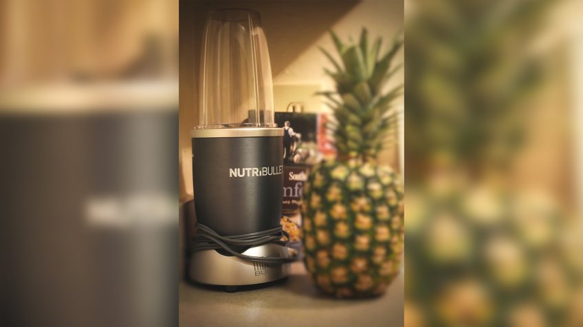 Cary,NC/US-May 18 2019 Nutribullet on the kitchen counter with a pineapple and recipe book waiting to make tasty treat.