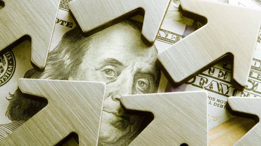 A close up of upwardly pointing arrows surround the face of Benjamin Franklin on the U.