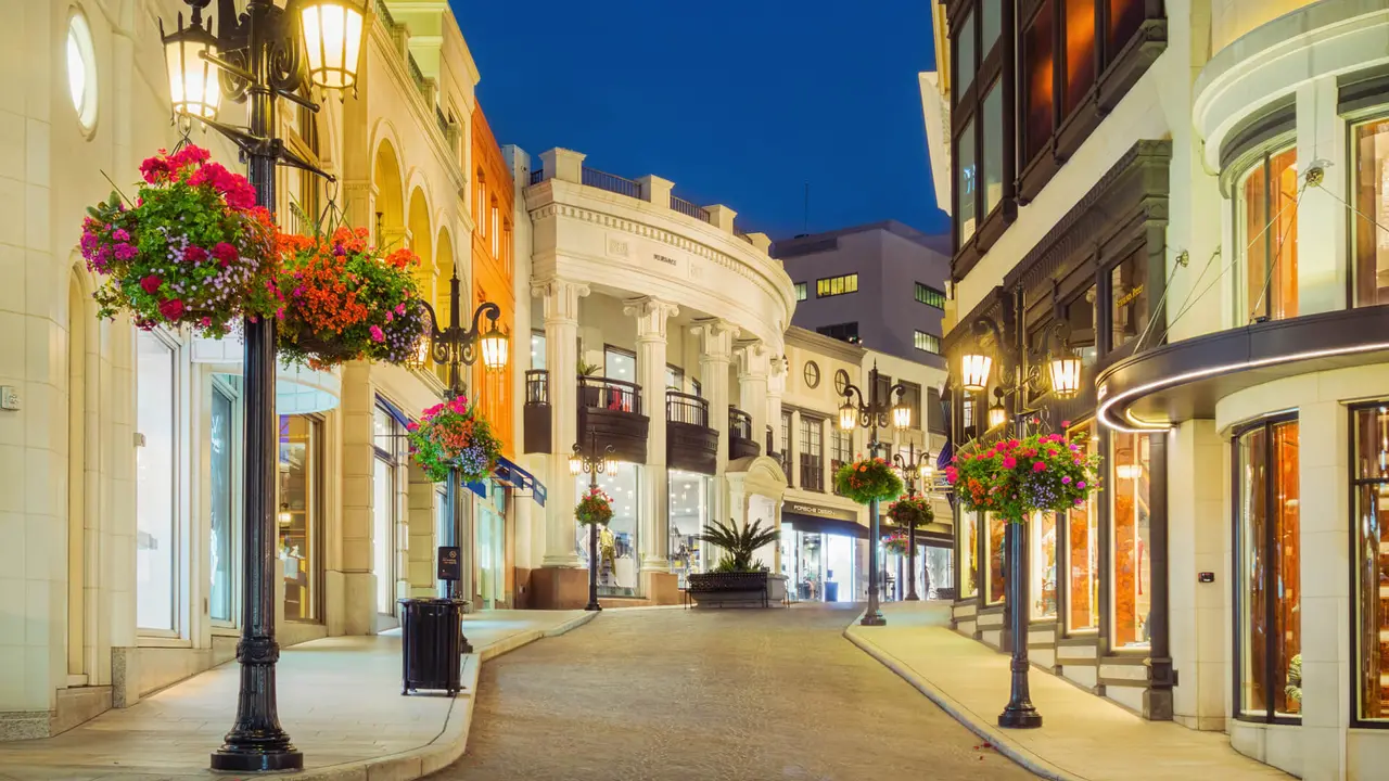 Photo of Rodeo Drive with illuminated stores in Beverly Hills, Los Angeles, California, USA at twilight blue hour.