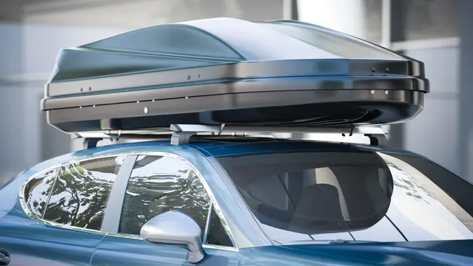 Modern silver car for traveling with a roof rack.