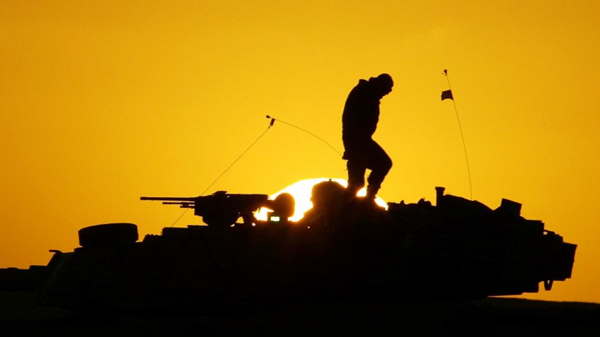 US Soldier walks atop armored tank during Iraq War