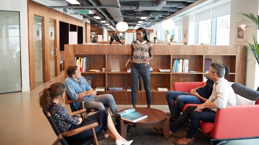 Casually Dressed Businessmen And Businesswomen Having Informal Meeting In Modern Office.