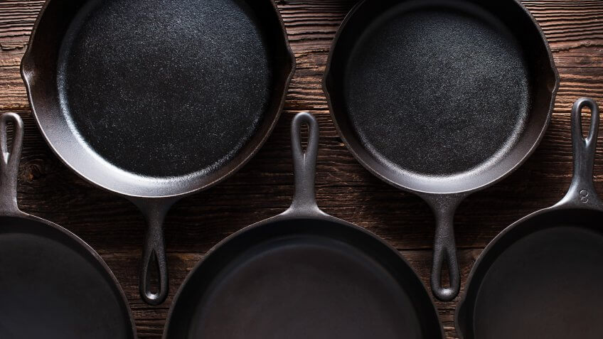 Cast Iron Skillets on Rustic Wood Table.