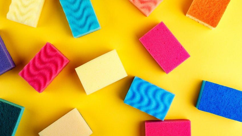 many multi-colored washcloths are scattered on a bright yellow background.