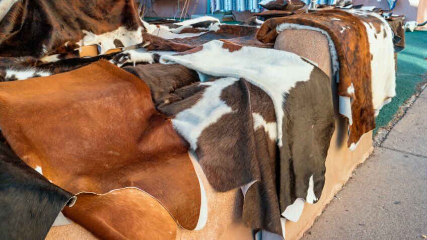 Stock photograph of colorful cowhide rugs on display in a market in downtown Santa Fe New Mexico USA.