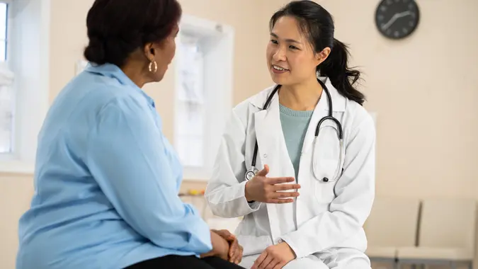 A senior woman of african descent listens to her doctor explain the outcome of her most recent tests.
