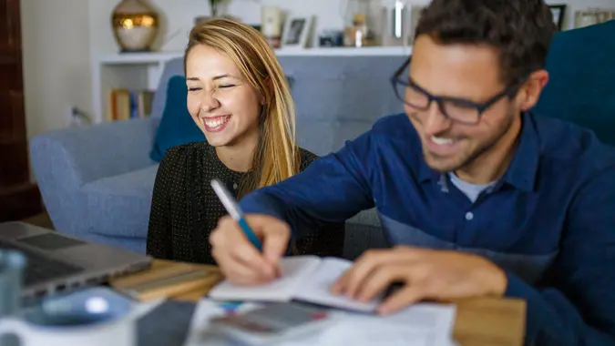 Couple at home sorting through bills and taxes.