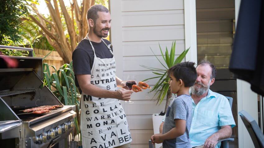 Three generations of the family enjoying a barbecue of prawns and drinks.