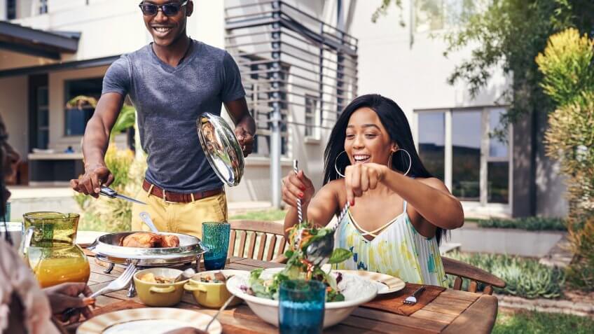 Shot of a happy family having lunch out in the backyard.