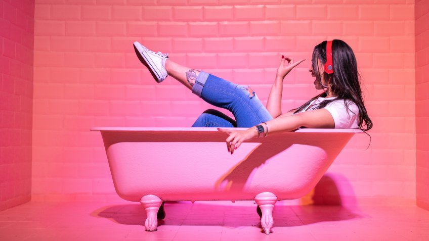 girl with headphones in pink bathtub set.