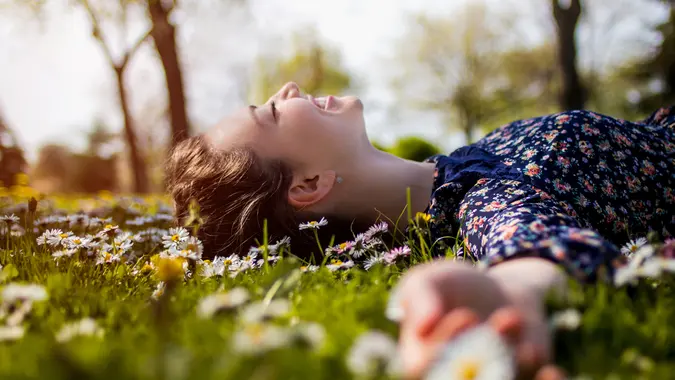 Pretty young teenage girl laying on a grass.
