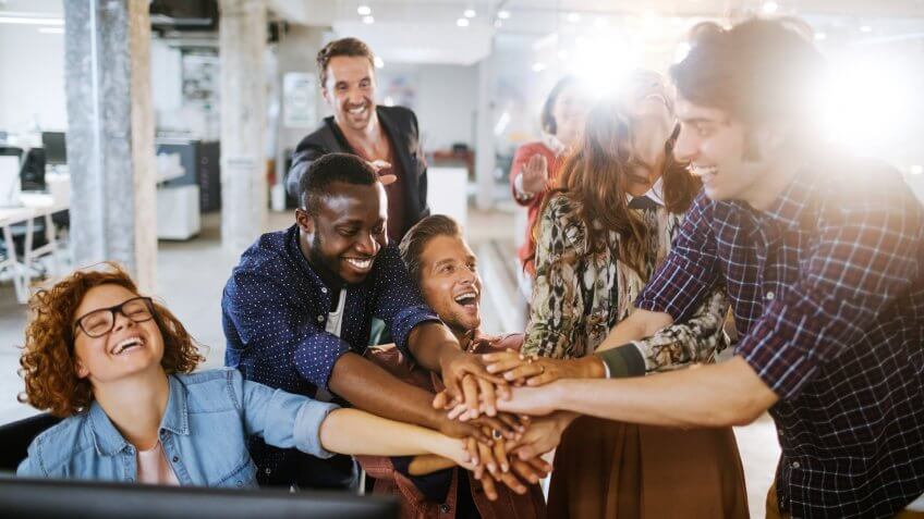 Close up of a group of architects joining hands.