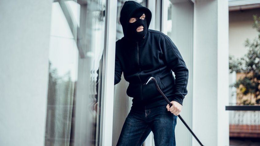 Robber breaks house door.