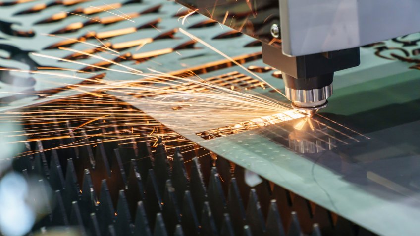 The fiber laser cutting machine cutting the sheet metal plate with the sparking light.