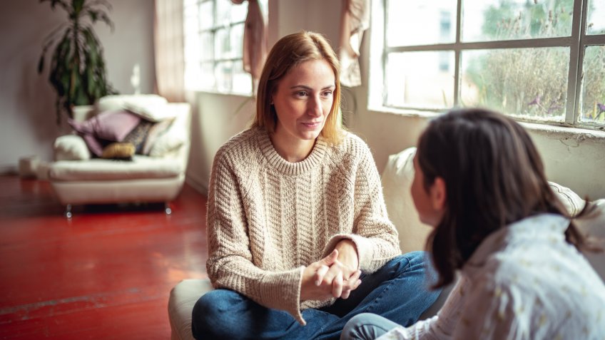 Mother and daughter at home having a talk at home.