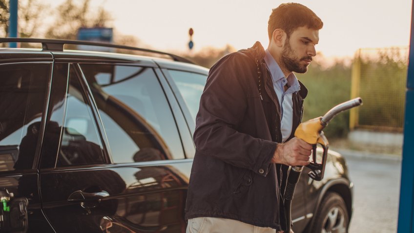 One man, pouring gasoline in his car at the gas station.