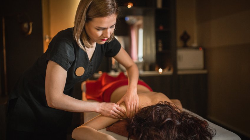 Young woman relaxing and enjoying massage at spa centre.
