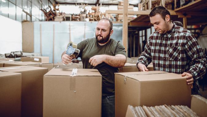 Team of Warehouse Workers Packing Boxes for Shipment.