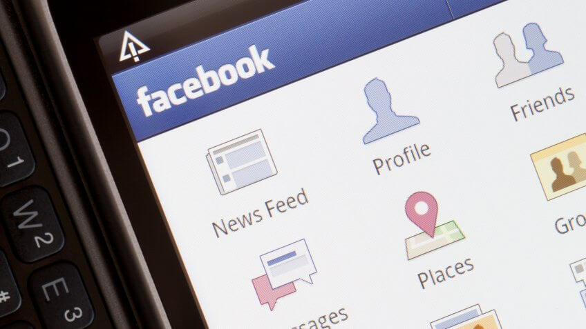 Krakow, Poland - March 27, 2011: HTC Desire Z phone isolated on grey background with open keyboard showing the mobile version of the facebook social network.