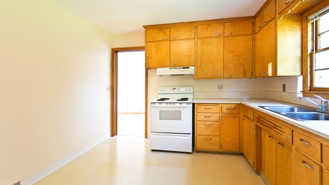 An empty vacant 1950s mid-century modern bungalow style house in the mid-west of United States with old fashion period kitchen.