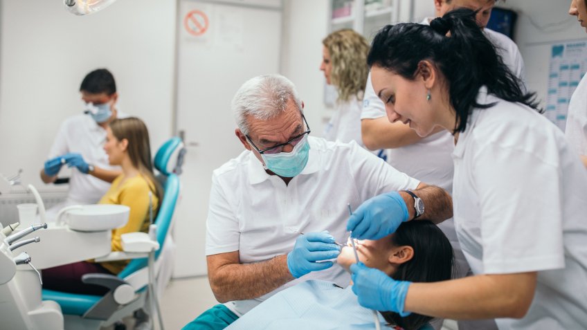 Group of people, dentists and assistants taking care of their patients.