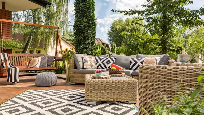 New design villa patio with comfortable rattan furniture and pattern carpet.