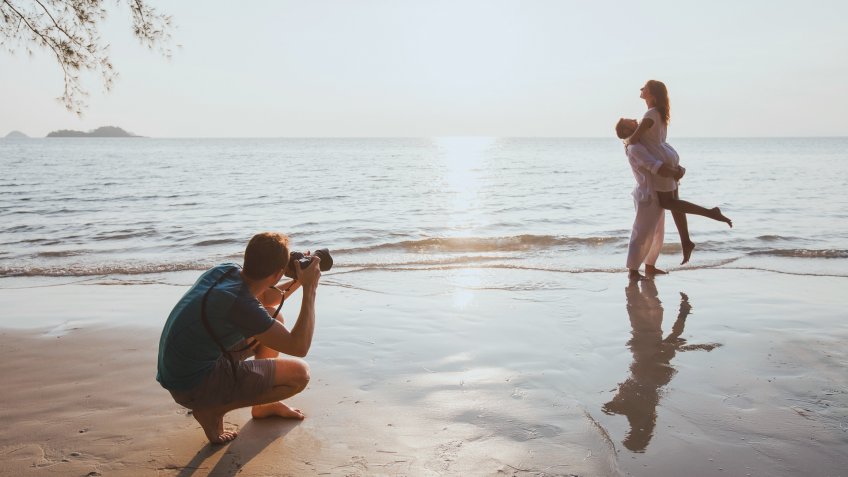 portrait photographer capturing couple on beach