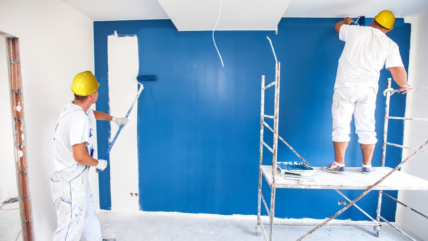 Room painter paints a wall in a new home.