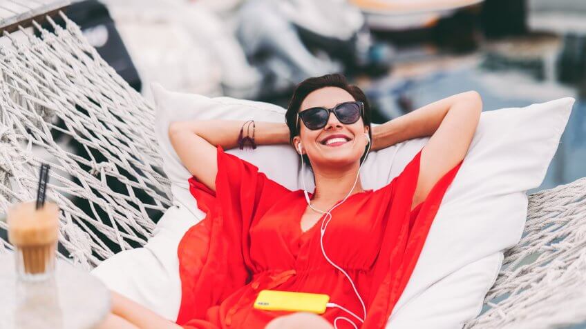 Relaxed woman in hammock enjoying a beach holiday.