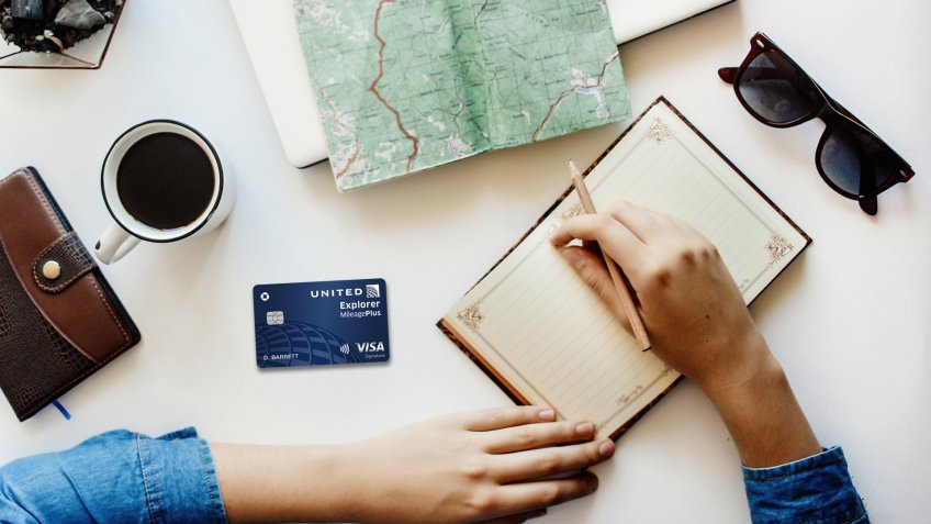 hipster traveler girl hands on notebook and old map on laptop wallet coffee and sunglasses flat lay.