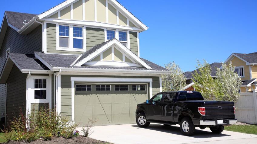 Pretty new two storey home with 4X4 truck parked in driveway.