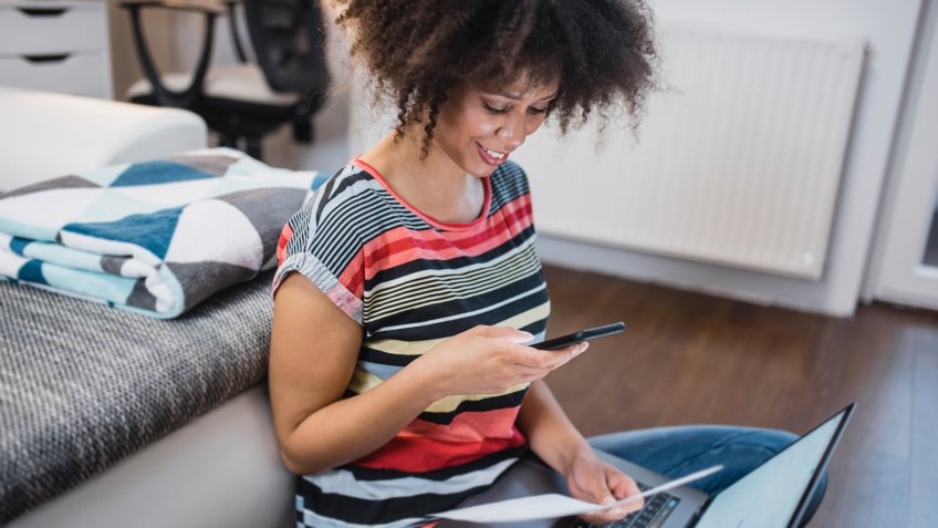 Young woman paying the bills at home.