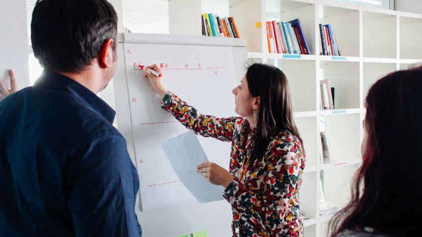 woman writing on board in start up office