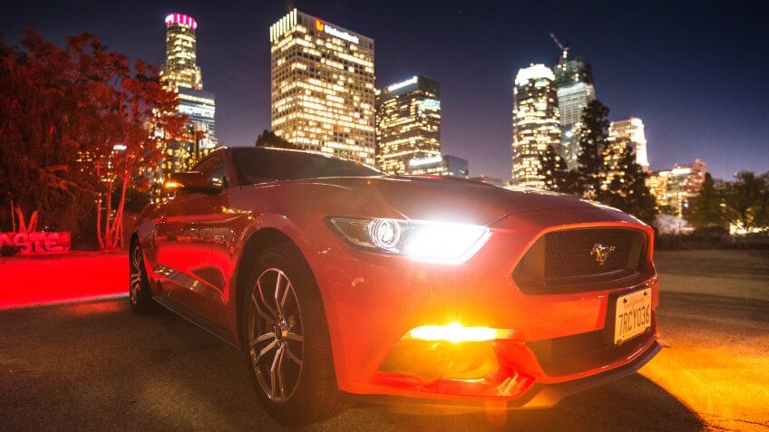 Los Angeles, California, USA - March 22, 2016: Front view of a red Ford Mustang GT car parked on the street against the Los Angeles city downtown.