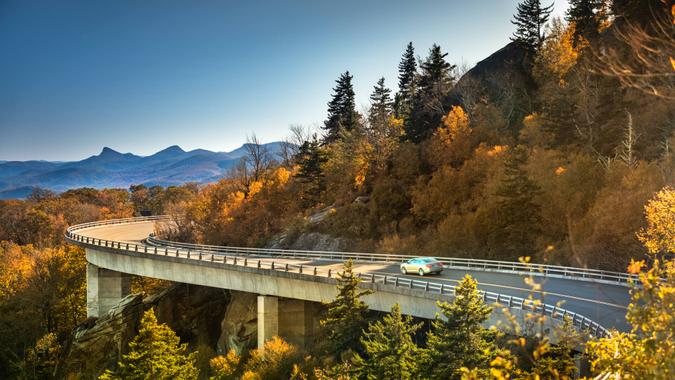 Cars travel on the Linn Cove Viaduct highway road on the Grandfather Mountain along the Blue Ridge Parkway in autumn North Carolina USA.