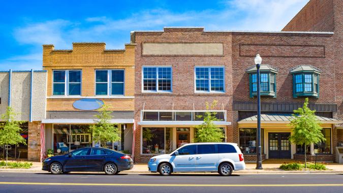 Downtown retail building storefronts form geometric patterns against a deep blue sky.