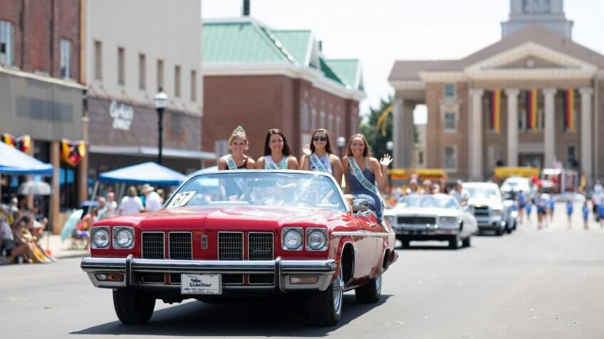 Jasper, Indiana, USA - August 5, 2018: The Strassenfest Parade, A group of Beauty queens, riding on the back of a classic car during the parade.