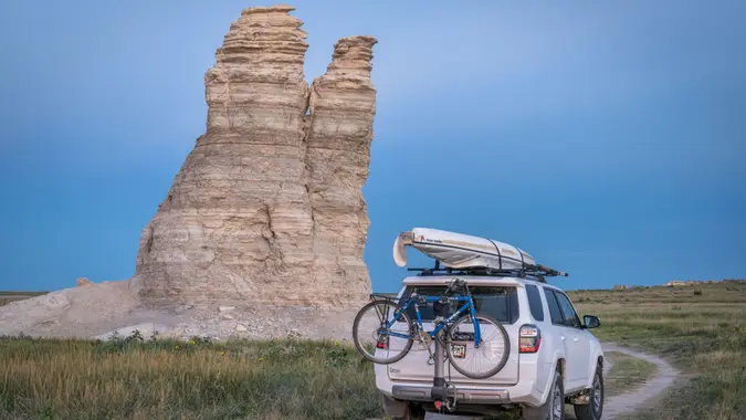 Castle Rock, KS, US - July 25, 2016: Family driving Toyota 4Runner SUV (2016 Trail edition) on summer vacations carrying a kayak and bike in Kansas back country.