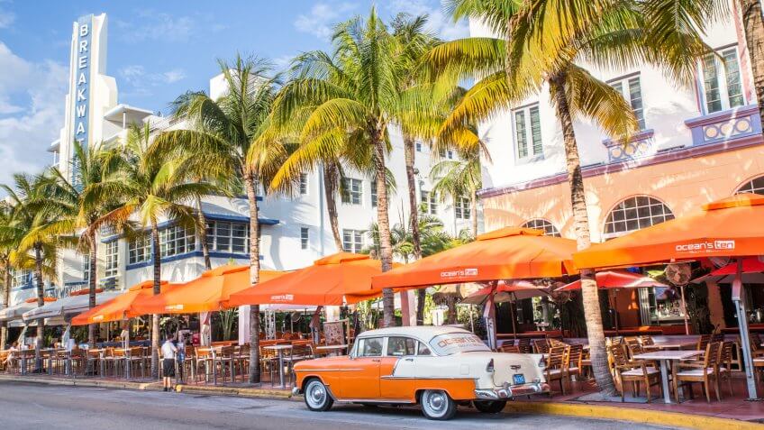 Miami Beach, Florida, USA - April 25, 2016: View along Ocean Drive along South Beach Miami in the historic Art Deco District with hotels, restaurant, people and classic car visible.