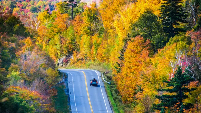 An automobile applies its brakes as it approches a sharp curve on the roadway through Camel's Hump State Forest (Rte.