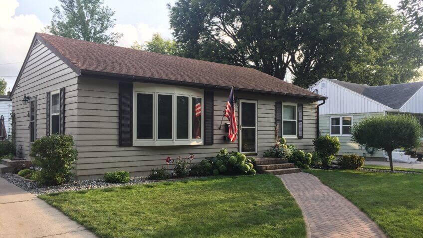 Old-Style leaving house in a small city with the American flag.